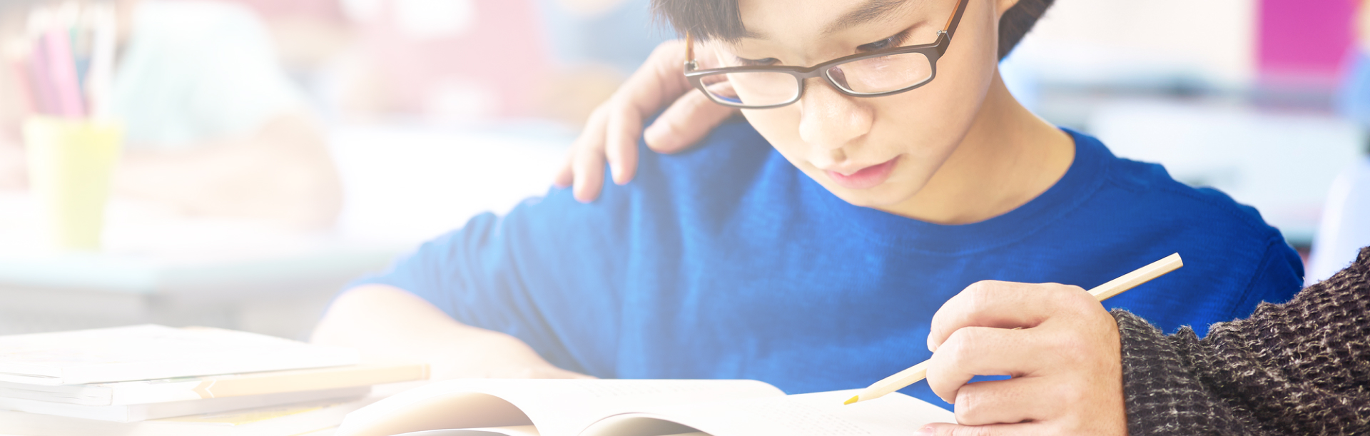 child looking at note with instructor